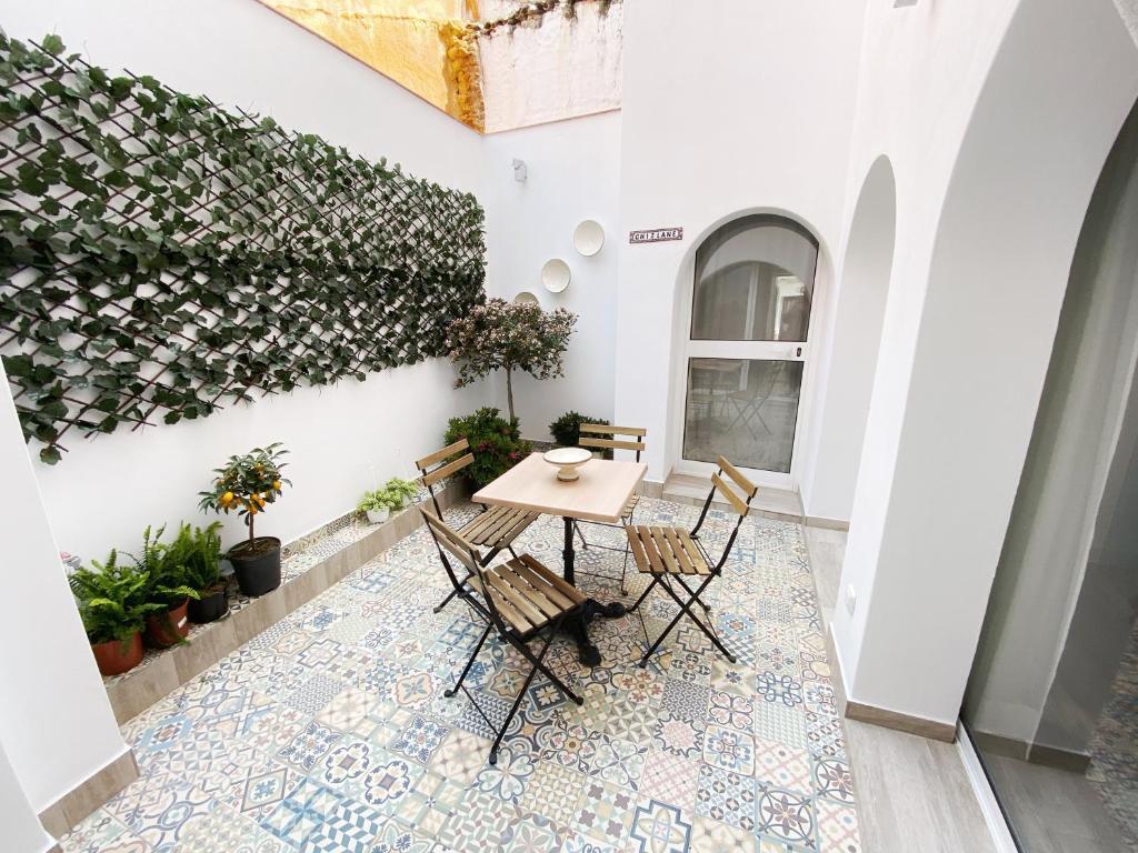 un patio con mesa y sillas en un suelo de mosaico en Casa Kalameta, en Estepona