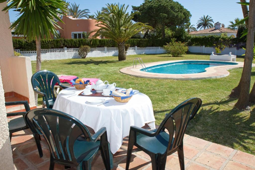 a table and chairs in front of a swimming pool at Villas Marbella in Marbella