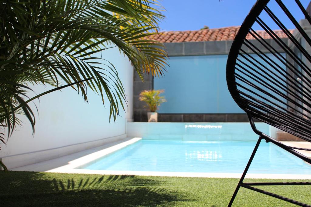una piscina con una silla junto a una casa en Villa Allureh Emblematic Lodging, en Santa Lucía