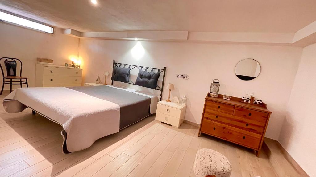 um quarto com uma cama grande e uma cómoda em madeira em Suite Follonica Beach em Follonica