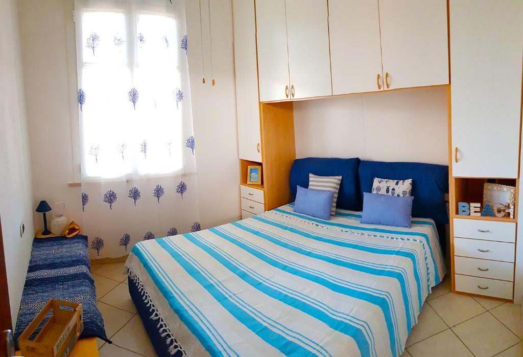 een slaapkamer met een bed met blauwe en witte lakens bij Suites Pratoranieri Beach in Follonica