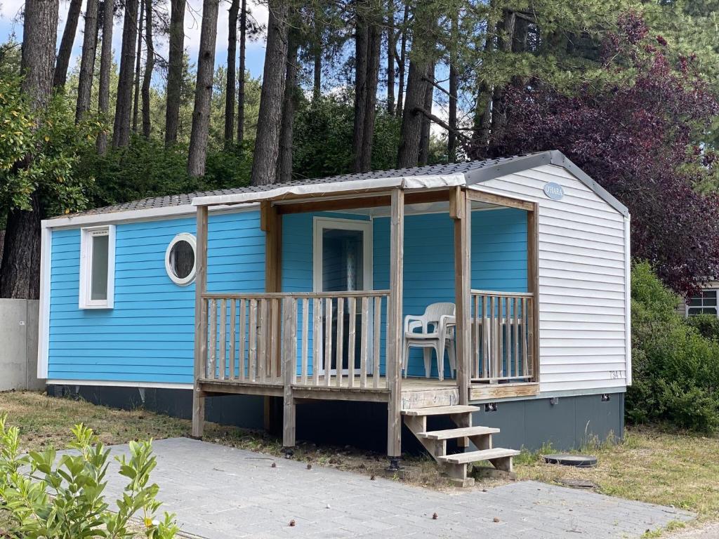 een blauw en wit tiny house met een veranda bij Neat chalet with microwave Antwerp at 39 km in Rijkevorsel