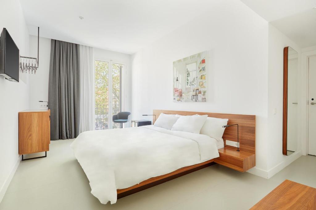 1 dormitorio blanco con 1 cama grande y TV en Sonder La Casa del Sol en Barcelona