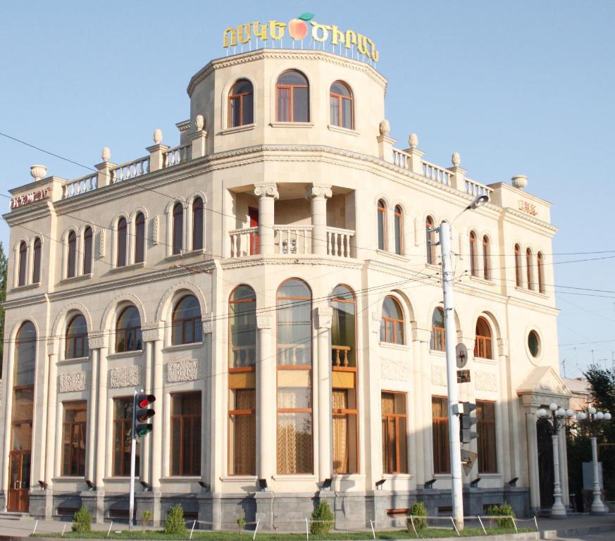 a white building with a sign on top of it at Golden Apricot in Gyumri