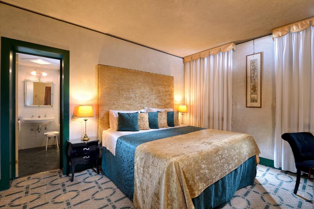 um quarto de hotel com uma cama e uma casa de banho em Palazzo del Giglio em Veneza
