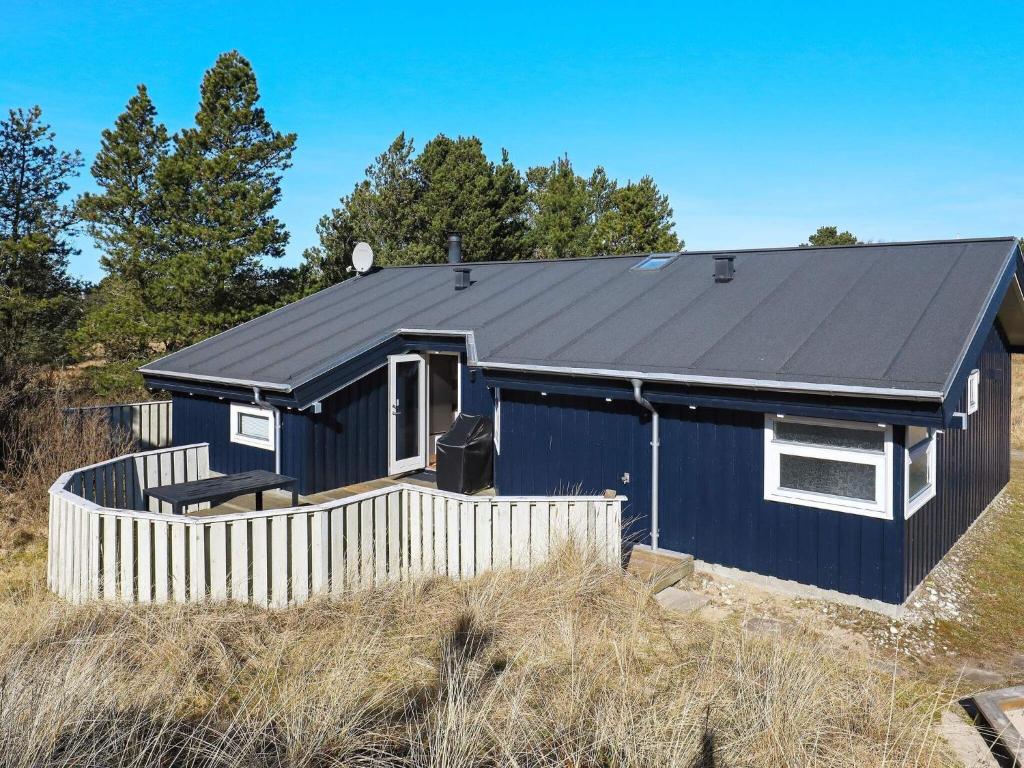 uma casa azul com um telhado preto em 8 person holiday home in Bindslev em Bindslev