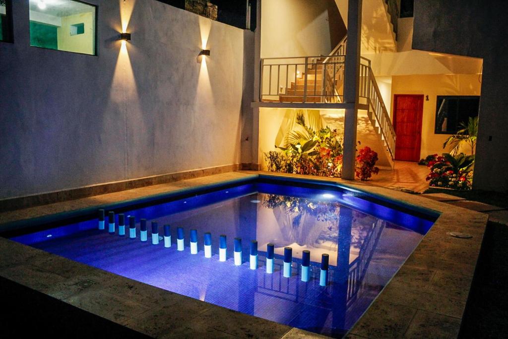 una piscina con iluminación azul en una casa en HOTEL ANTHURIUM, en Jalcomulco