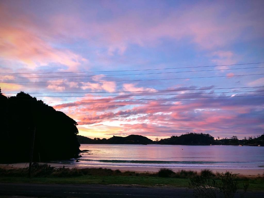 una puesta de sol sobre el agua con un cielo nublado en Butterfield Beach Studio Car petrol and breakfast provisions included, en Half-moon Bay