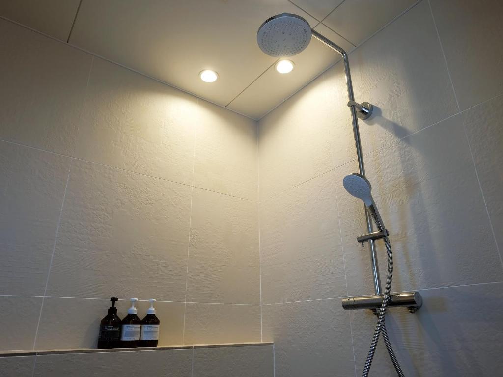 a shower with a shower head in a bathroom at CHULAX OKINAWA YOMITAN【Designer Condominium Hotel】 in Yomitan