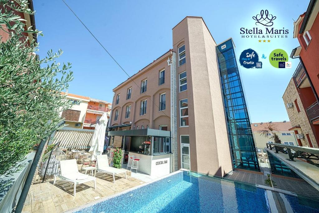 um hotel com piscina em frente a um edifício em Hotel Stella Maris em Vodice