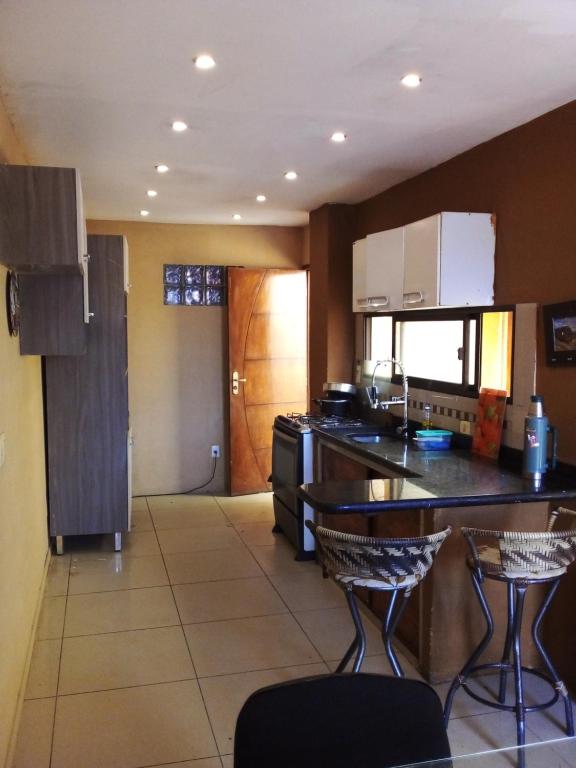 - une cuisine avec un comptoir et quelques chaises dans l'établissement N1 1 Apartamento Completo 2 Dormitorios en Centro de Artigas, à Artigas