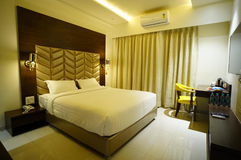 Habitación de hotel con cama, escritorio y cama sidx sidx en Orange Tree Hotels, en Nagpur