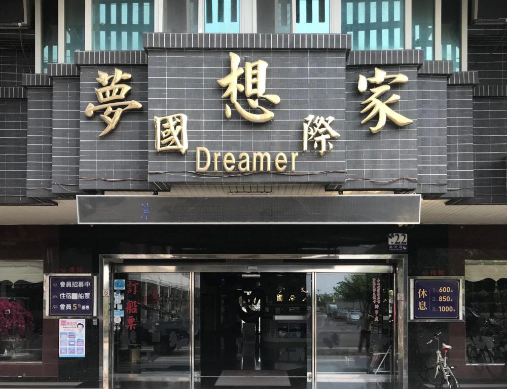 un negozio di fronte con cartelli cinesi sul davanti di un edificio di Dreamer Hotel a Budai