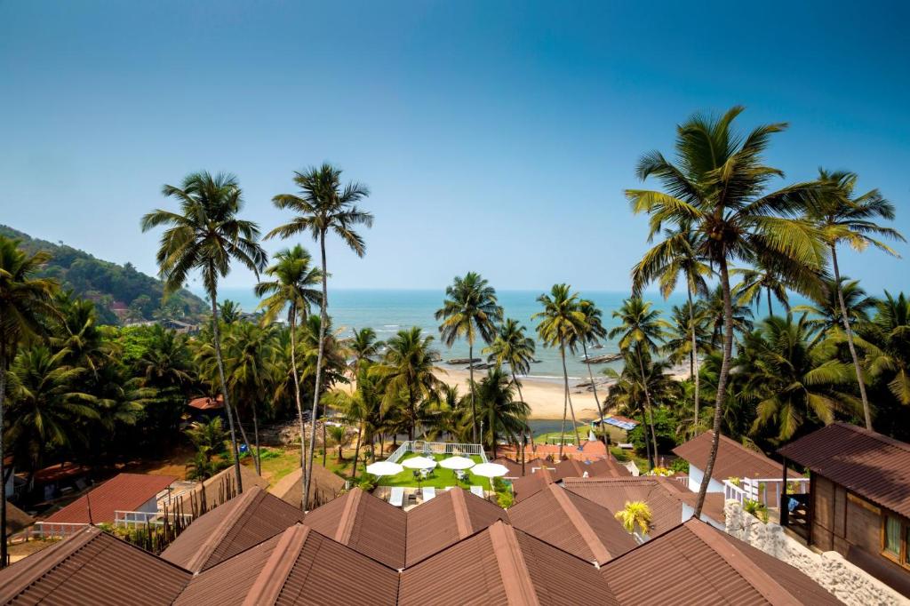 a view of the beach from a resort with palm trees at Stone Wood Beach Resort, Vagator in Vagator