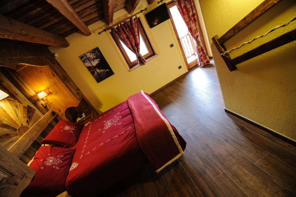 ein Wohnzimmer mit einem roten Sofa und Holzböden in der Unterkunft Clé du Paradis in Bionaz