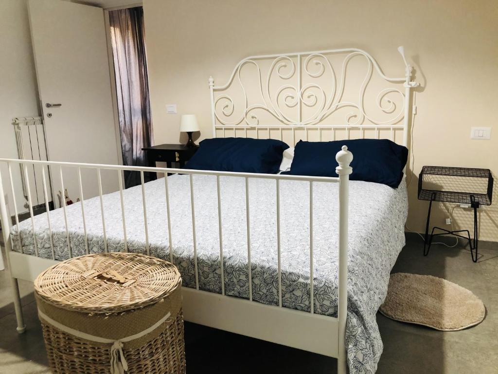 un letto bianco con cuscini blu in una camera da letto di Casa delle Rose in centro a Latina
