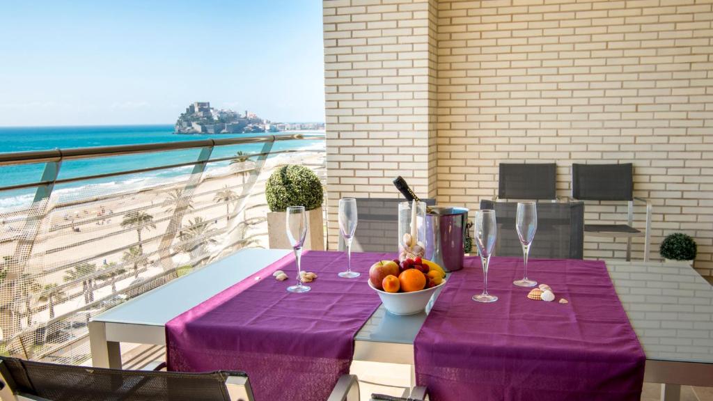 a table with a purple table cloth and a bowl of fruit at Playa Norte 7ºG in Peniscola