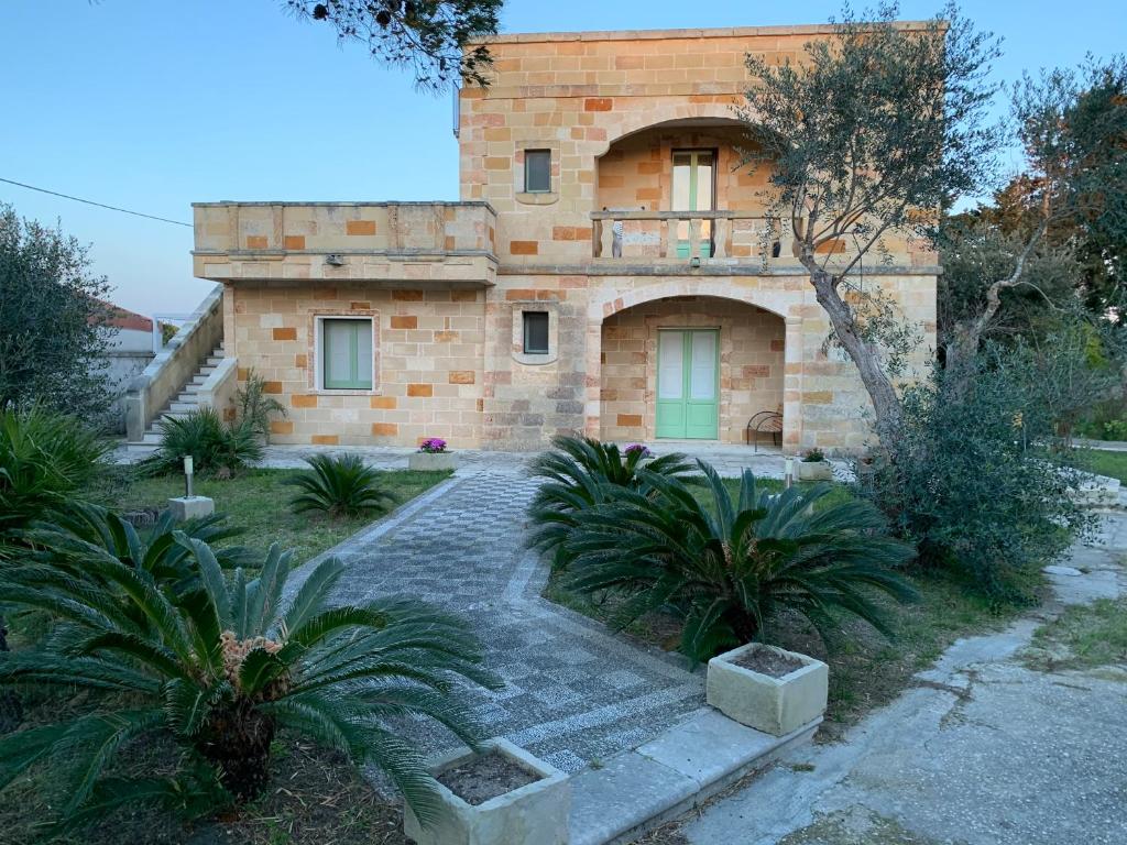 a brick house with a stone pathway in front of it at Eden MONOLOCALE Torre dell Orso in Torre dell'Orso