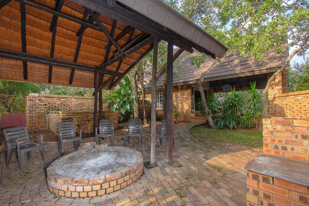 a patio with a fire pit and chairs and a building at NJIRI LODGE - Your part of Africa in Marloth Park