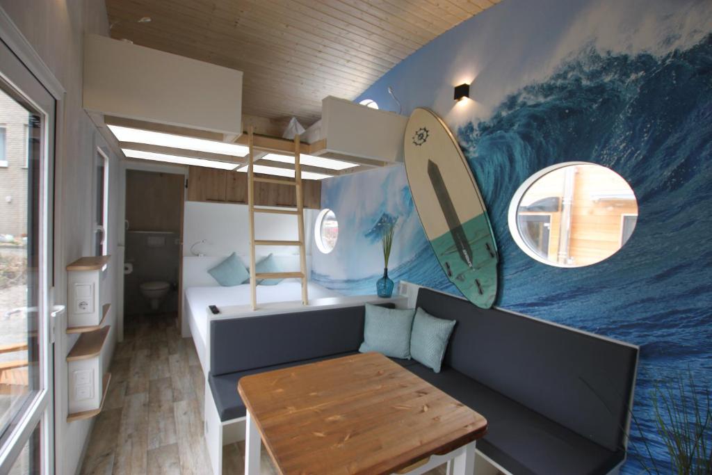 Habitación con tabla de surf pintada en la pared. en Tiny Wave Tiny House auf dem Campingplatz Strandgut, en Cuxhaven