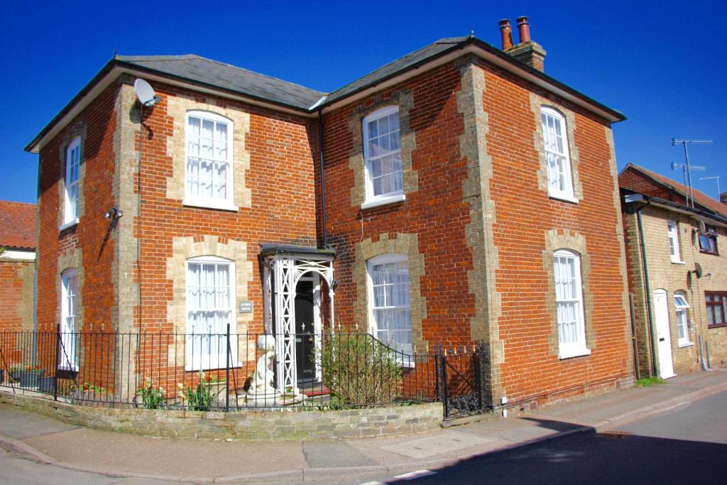 an old red brick building with white windows at Seaside Luxury House on the Suffolk Coast in Saxmundham