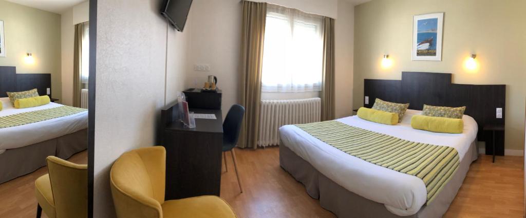a hotel room with two beds with yellow pillows at Cit'Hotel Atlantis in Royan