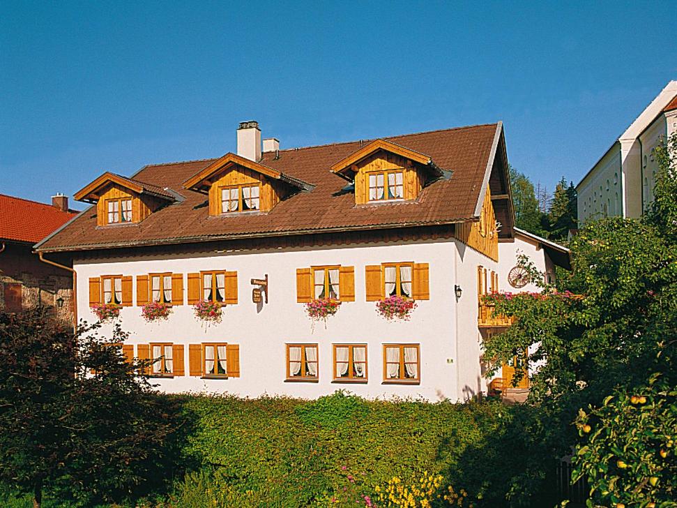 uma grande casa branca com um telhado castanho em Pension Berg&Bleibe Wertach em Wertach
