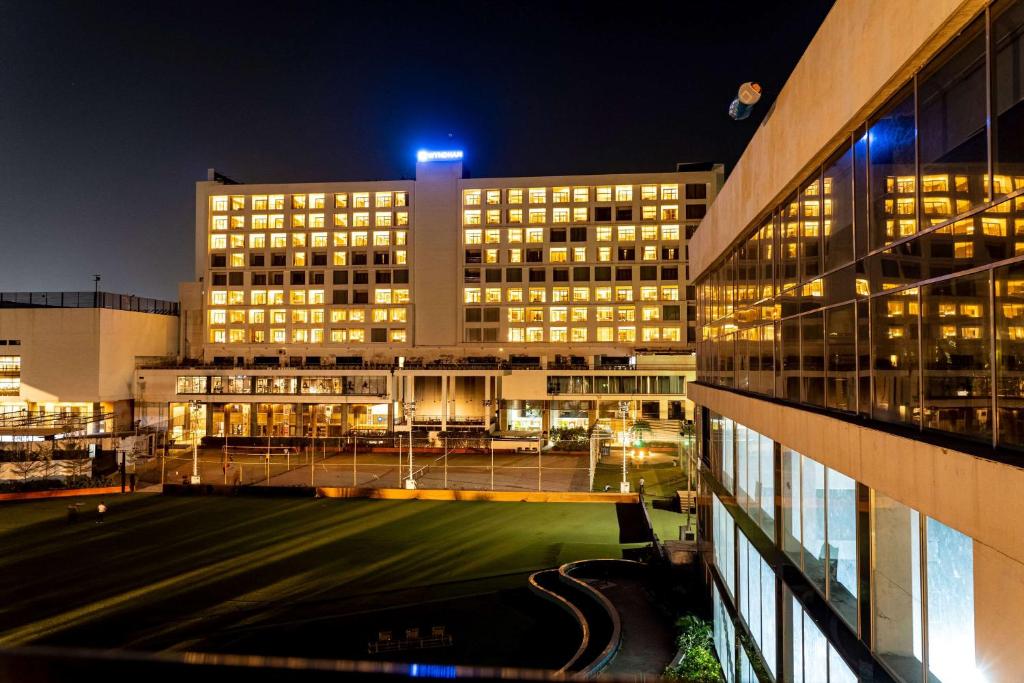 un bâtiment avec un champ devant lui la nuit dans l'établissement Wyndham Ahmedabad Shela, à Ahmedabad