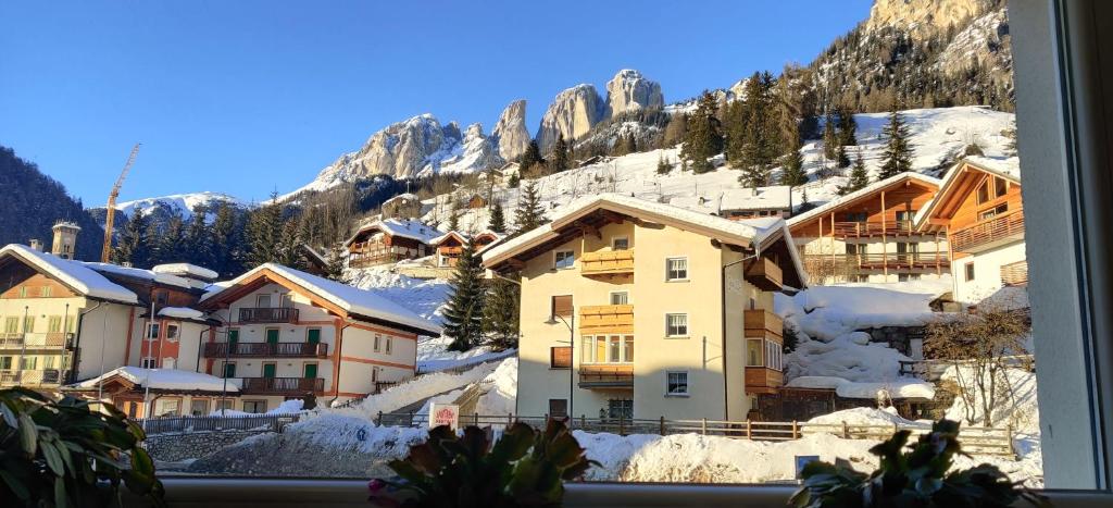 widok na śnieżną górę z okna w obiekcie Laurino Apartment w mieście Campitello di Fassa