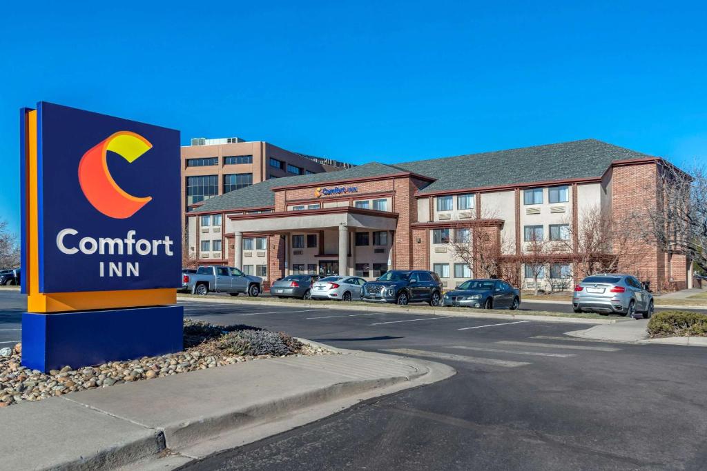 un panneau indiquant une auberge confortable en face d'un parking dans l'établissement Comfort Inn Denver Southeast Area, à Aurora