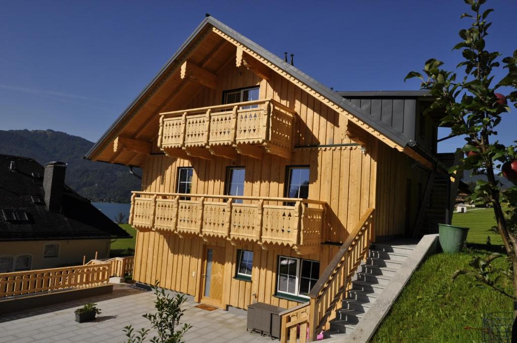 een groot houten huis met terrassen aan de zijkant bij Ferienwohnungen Holzidylle in St. Wolfgang