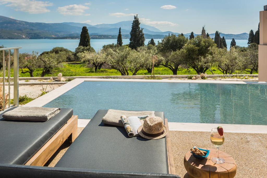 uma piscina com uma mesa e um copo de vinho em Ionian Village em Lixouri