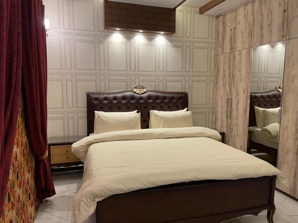 ラホールにあるRoyal Three-Bedroom Villa Dha Phase 6 Lahoreの大きなベッドと鏡のある寝室
