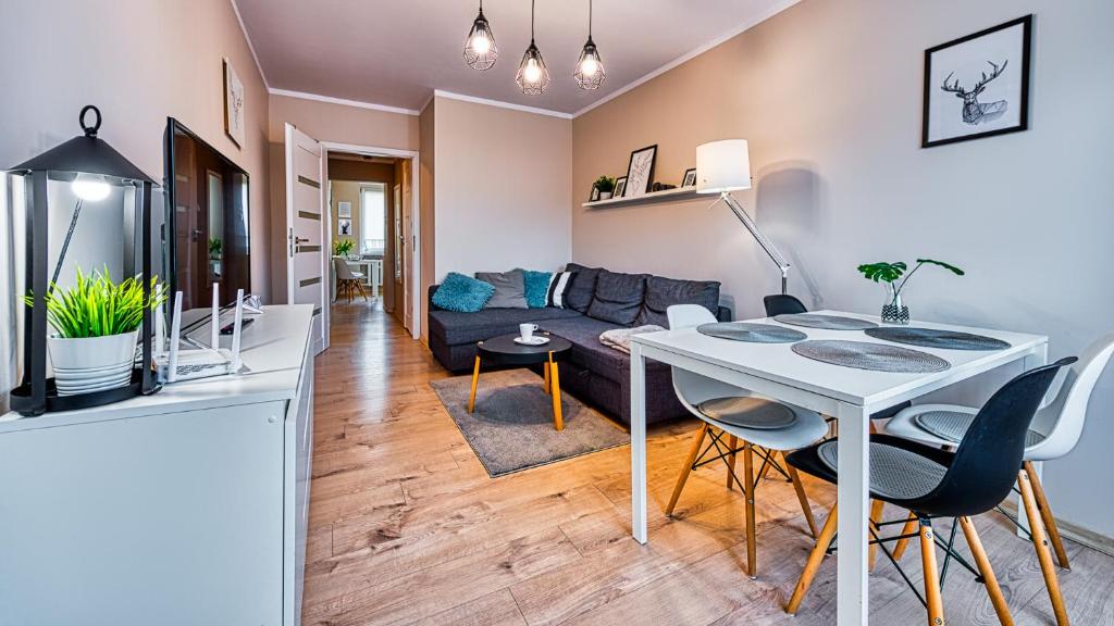 een woonkamer en eetkamer met een witte tafel en stoelen bij Apartament Emili - 5D Apartamenty in Szklarska Poręba