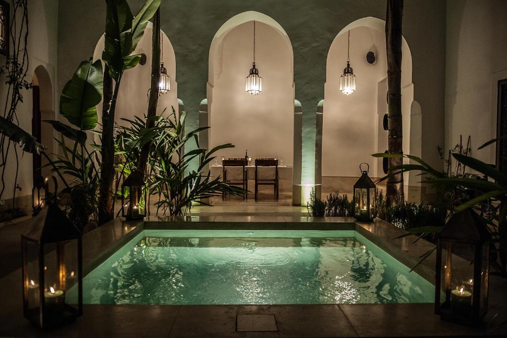 an indoor pool in a church with potted plants at Riad Jaaneman in Marrakesh
