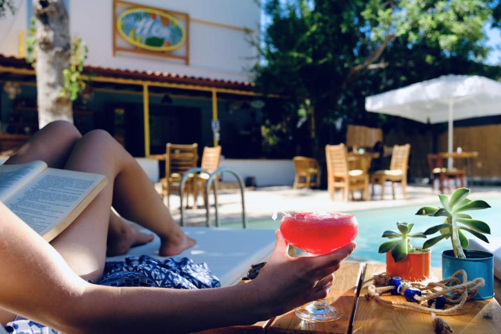 a woman laying on a towel with a book and a drink at Kaş 11 Oda Boutique Pension in Kas