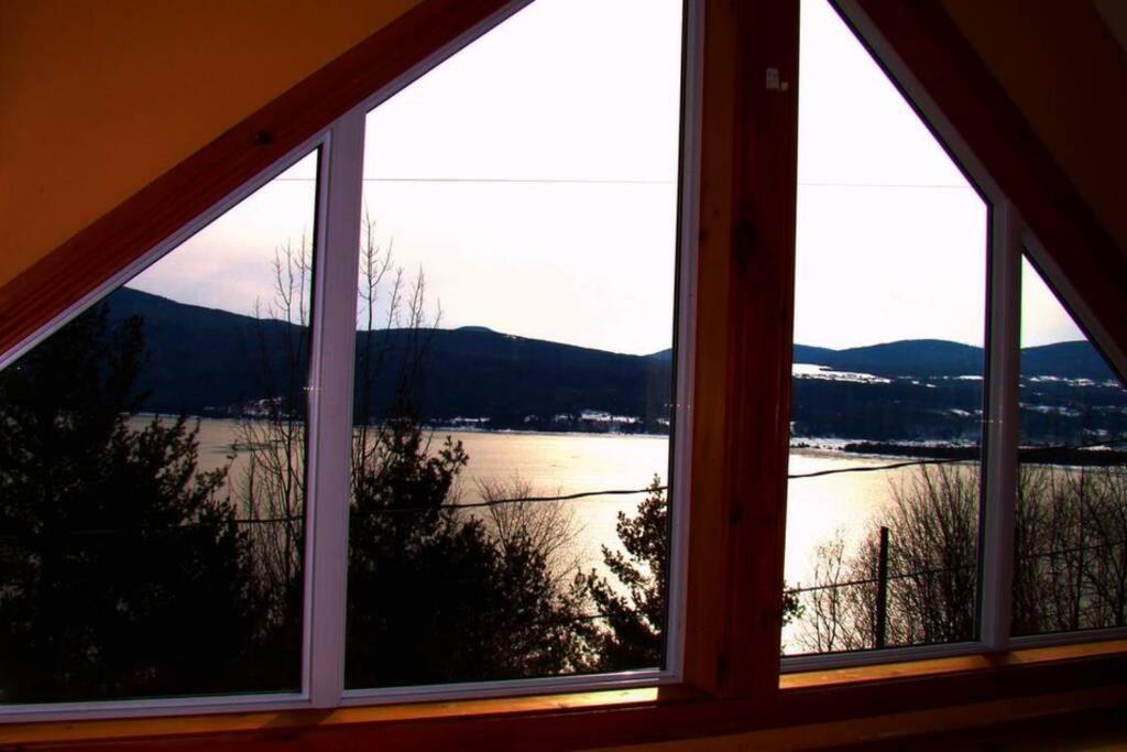 una ventana con vistas al lago desde una casa en Le Très-Chic - SPA, billard, souvenirs en Baie-Saint-Paul