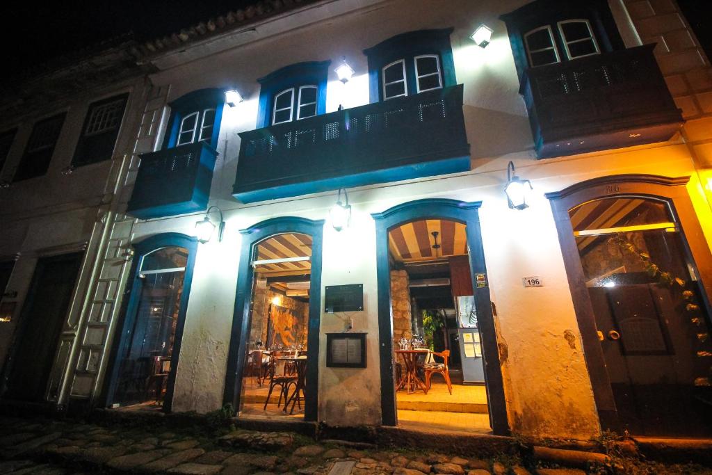 a building with blue and white trim at night at Pousada Bartholomeu in Paraty