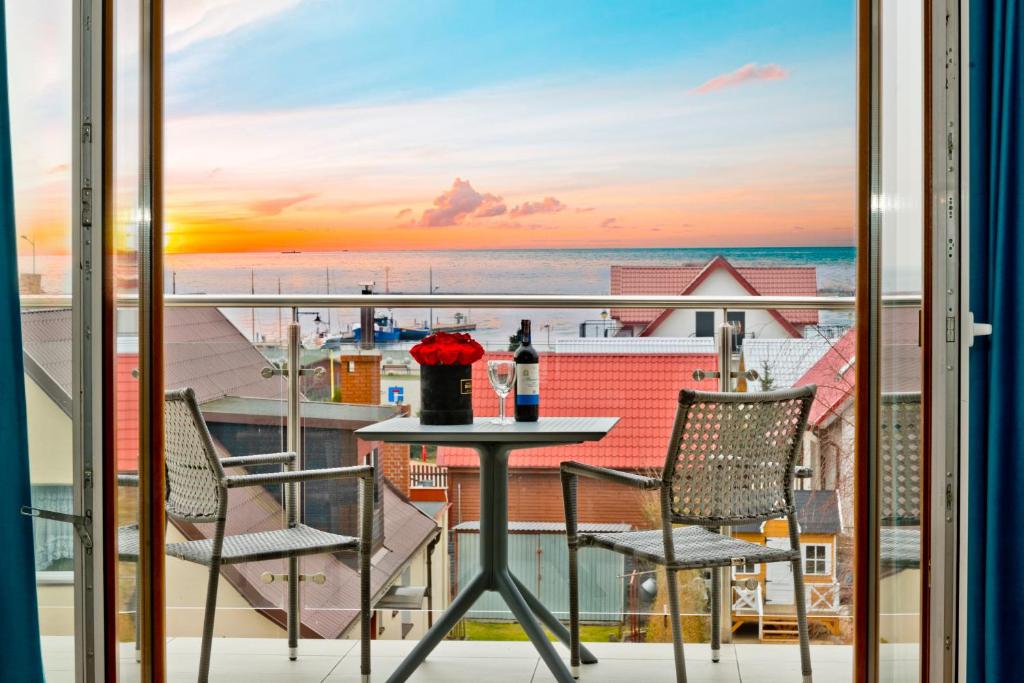 een balkon met een tafel en stoelen en uitzicht op de oceaan bij BlueApart Marina Jastarnia in Jastarnia