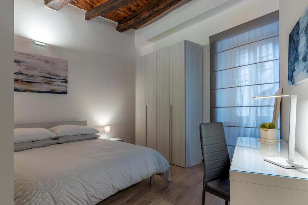 um quarto com uma cama e uma secretária com uma cadeira em Residenza San Leonardo - Viterbo Centro Storico em Viterbo