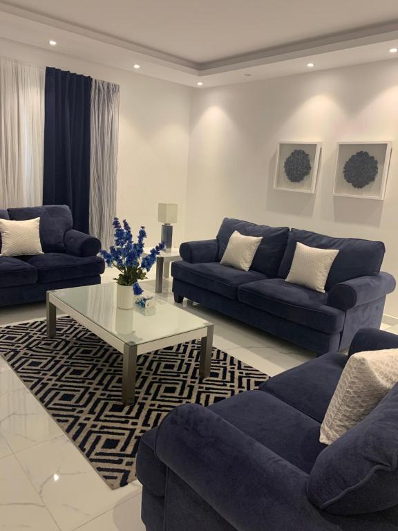 uma sala de estar com sofás azuis e uma mesa de centro em Jamal Royal Apartments em Medina