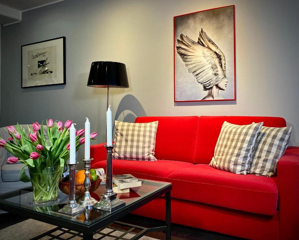 un divano rosso in soggiorno con tavolo di CityHomeMunich a Monaco
