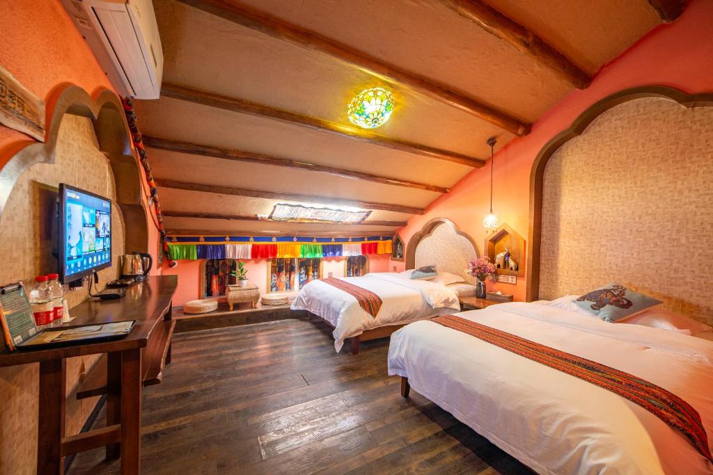 una stanza con due letti e una televisione di Zhangjiajie Highlights Guesthouse a Zhangjiajie