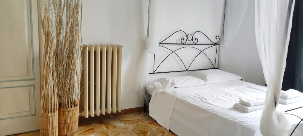 een slaapkamer met een wit bed en een radiator bij Urban central Florence in Florence