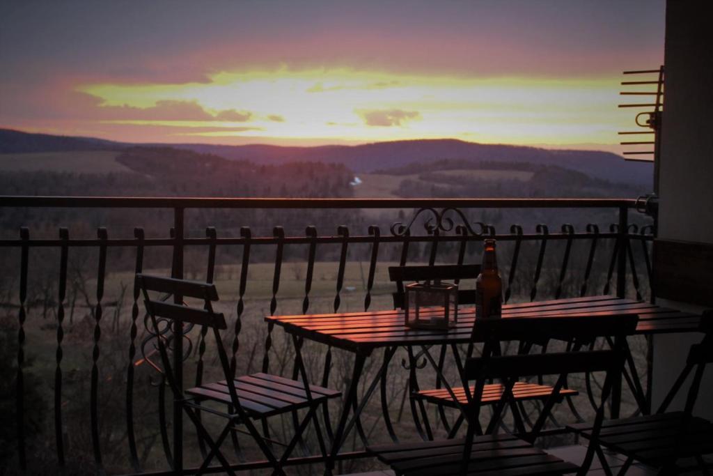 d'une table et de chaises sur un balcon avec vue. dans l'établissement Pod Wiśnią Agroturystyka Kalwaria Pacławska, à Kalwaria Pacławska