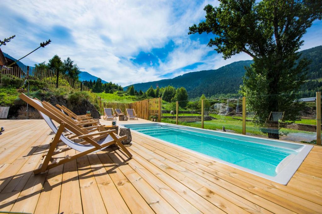 a swimming pool on a wooden deck with a chair at Mountain Hostel Tarter in El Tarter