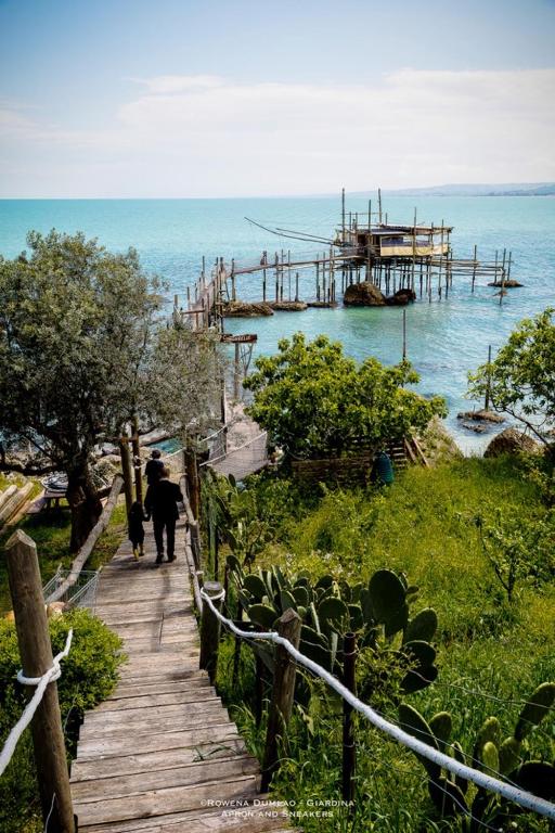 osoba idąca drewnianą ścieżką blisko oceanu w obiekcie Casa Mare Ludovica w mieście Vasto