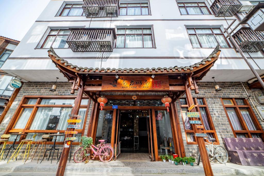 un edificio con un cartello sulla parte anteriore di Zhangjiajie Highlights Guesthouse a Zhangjiajie