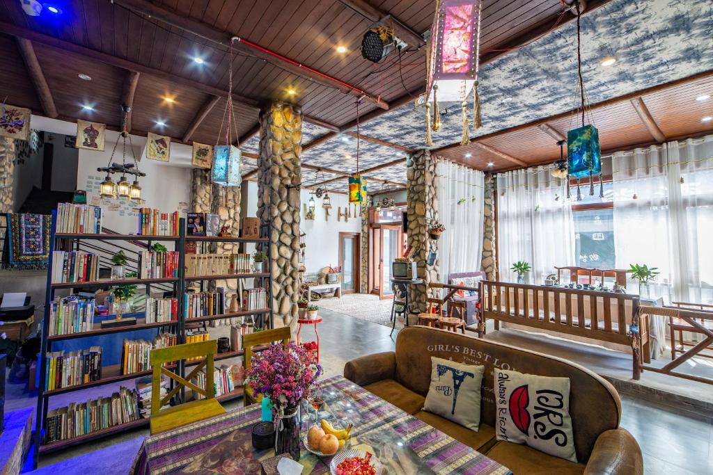 a library with bookshelves and couches in a room at Zhangjiajie Highlights Guesthouse in Zhangjiajie