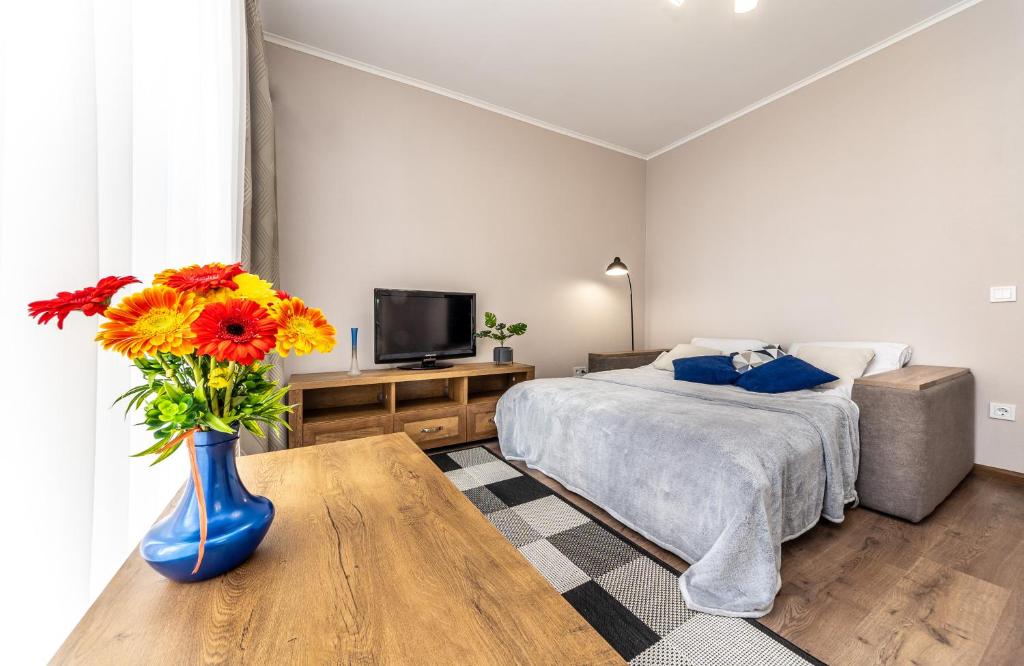 um quarto com uma cama e um vaso com flores sobre uma mesa em Стильная и уютная квартира в новом доме на Оболони em Kiev